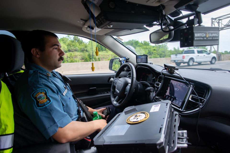 Kansas Highway Patrol Trooper Brock Simone uses a handheld remote to operate a vehicle-mounted radar system to track speeds of passing vehicles Friday morning on Interstate 70.