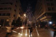 Teargas canisters fly during anti-government protest following Tuesday's massive explosion which devastated Beirut, Lebanon, Sunday, Aug. 9. 2020. (AP Photo/Hassan Ammar)