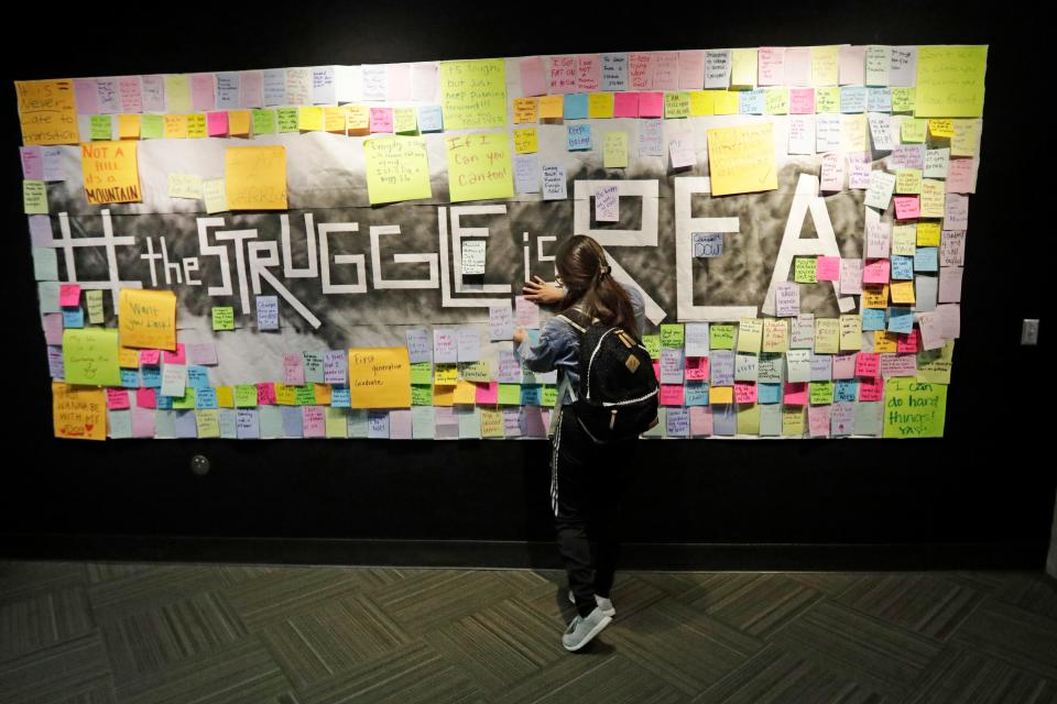 A student attaches a note to the Resilience Project board at the Utah Valley University in Orem in 2019. The purpose of the project is to let students know that it is OK to struggle.