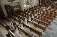 Catholic priest Fr. Ian Espartero walks past empty pews as he prepares to distribute communion to a few parishioners as a measure to prevent the spread of COVID19 at the Our Lady of Consolation Parish on Sunday, Aug. 2, 2020, in Quezon city, Philippines. Coronavirus infections in the Philippines continues to surge Sunday as medical groups declared the country was waging "a losing battle" against the contagion and asked the president to reimpose a lockdown in the capital. (AP Photo/Aaron Favila)