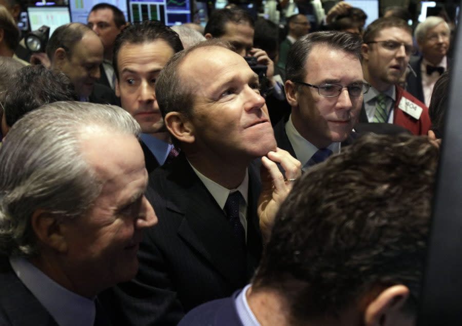 Then-Nielsen Company CEO David Calhoun, center, watches progress as he waits for the company's IPO to begin trading, Jan. 26, 2011, on the floor of the New York Stock Exchange. Calhoun will be stepping down at the end of the year from the top job at Boeing, which is under pressure from major airlines wanting to know how the company plans to fix problems in the manufacturing of its planes. (AP Photo/Richard Drew, File)