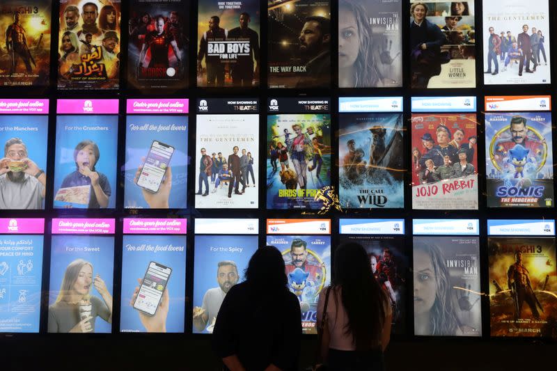 People look at the movies screen board at Mall of the Emirates during the reopening of malls, following the outbreak of the coronavirus disease (COVID-19), in Dubai