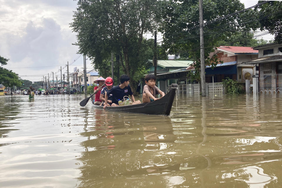 Local residents ride in a boat to down a flooded road in Bago, Myanmar, about 80 kilometers (50 miles) northeast of Yangon, Friday, Aug. 11, 2023. (AP Photo)