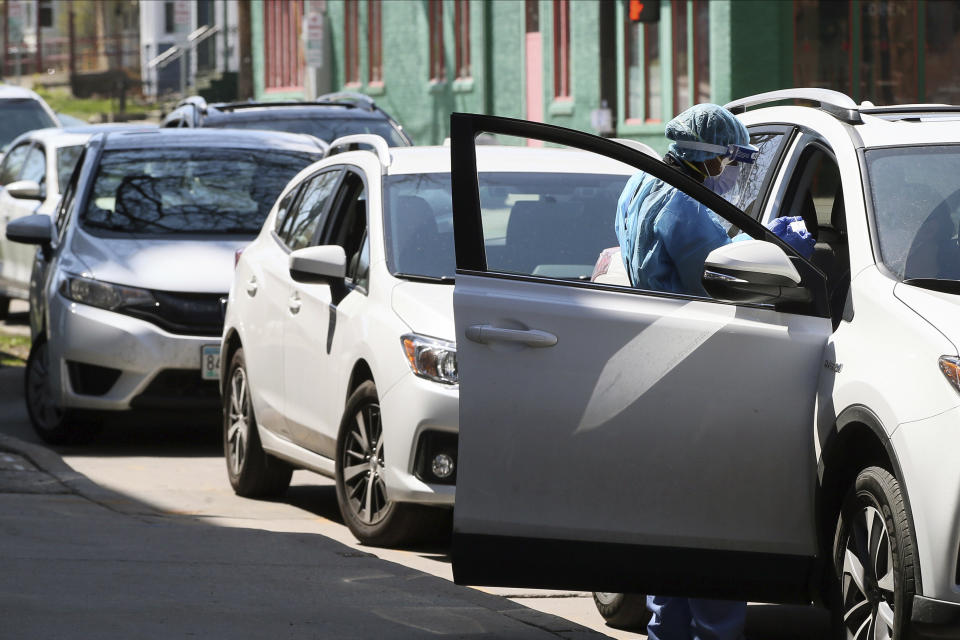 A health worker does a drive-up test on a driver at People's Center, Monday, April 27, 2020, in Minneapolis during expanded coronavirus testing as Minnesota Gov. Tim Walz tries to get the numbers of tests up. (AP Photo/Jim Mone)