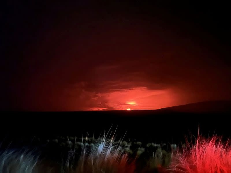 FILE PHOTO: Mauna Loa’s summit region glows during an eruption as viewed by a geologist of the Hawaiian Volcano Observatory