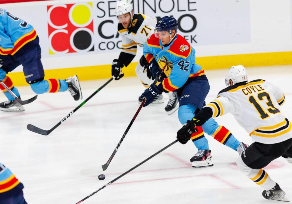 Florida Panthers defenseman Gustav Forsling (42) drives down the ice with the puck against Boston Bruins center Charlie Coyle (13) and Bruins left wing Taylor Hall (71) during the first period of an NHL game at FLA Live Arena on Wednesday, November 23, 2022 in Sunrise, Fl.