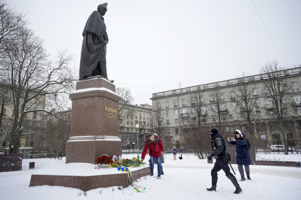 A police officer runs to detain a man who lays flowers to the monument of Ukrainian author Taras Shevchenko to mark one year since the start of the Russian campaign in Ukraine in St. Petersburg, Russia, Friday, Feb. 24, 2023. OVD-Info, a group that tracks political arrests, said that several people were detained in St. Petersburg after bringing flowers to the Shevchenko monument. (AP Photo/Dmitri Lovetsky)