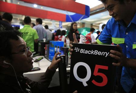 A worker prepares a Blackberry display during Digital Imaging Expo in Jakarta March 5, 2014. REUTERS/Beawiharta