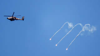 An Israeli Air Force Apache helicopter fires flares in the sky above the Israel-Gaza border August 7, 2022. REUTERS/Amir Cohen