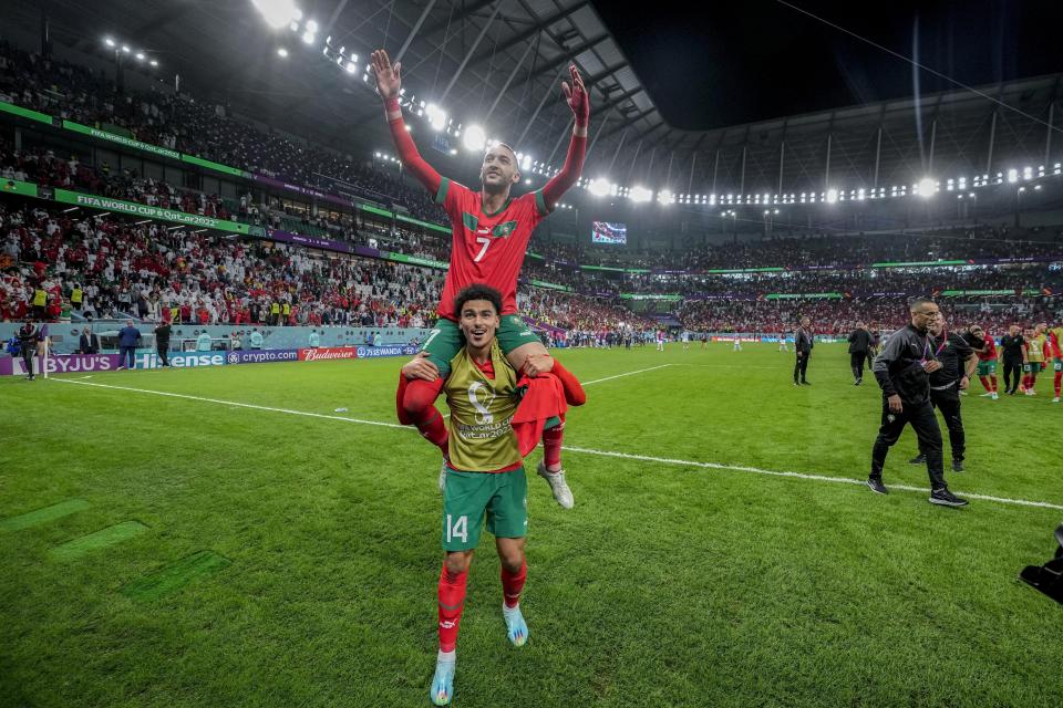 El marroquí Hakim Ziyech (encima) celebra con su compañero Zakaria Aboukhlal tras la victoria ante España en una tanda de penales en el partido por los octavos de final del Mundial, en Rayán, Qatar, el martes 6 de diciembre de 2022. (AP Foto/Martin Meissner)