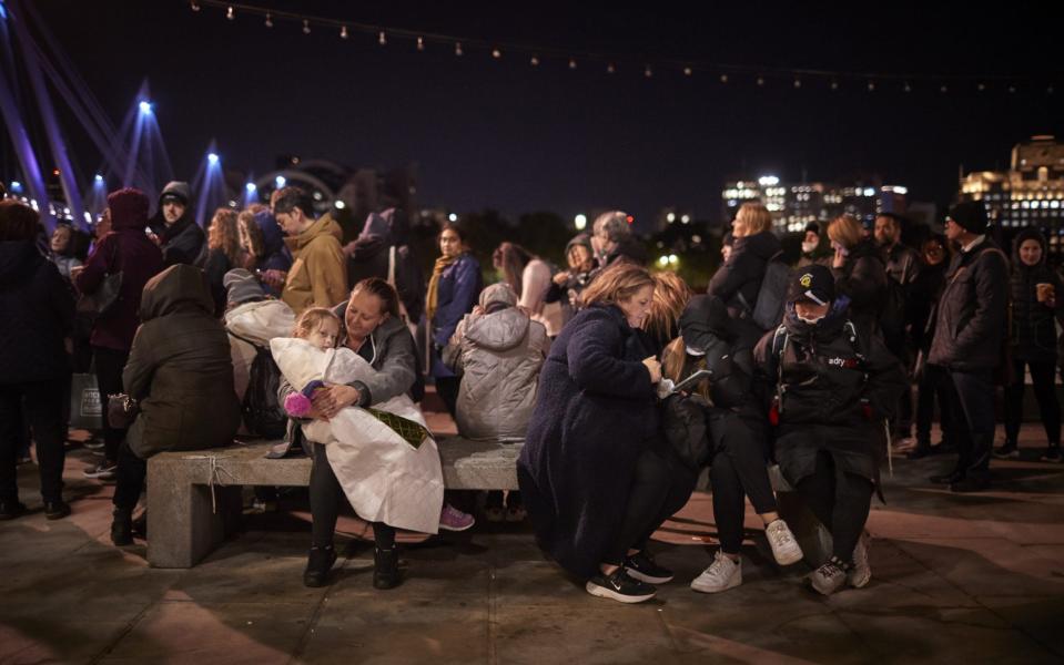 Lily-Mai, 6, tries to keep warm with her mother, Georgina, as they queue through the night to view the coffin of Queen Elizabeth II - Getty Images