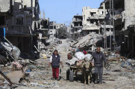 Palestinians walk through the destruction left by the Israeli offensive on Khan Younis, Gaza Strip, Friday, March 8, 2024. (AP Photo/Hatem Ali)