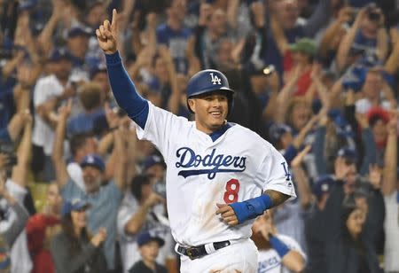 FILE PHOTO: Oct 27, 2018; Los Angeles, CA, USA; Los Angeles Dodgers shortstop Manny Machado (8) celebrates after scoring on a three run home run hit by outfielder Yasiel Puig (66) in the sixth inning against the Boston Red Sox in game four of the 2018 World Series at Dodger Stadium. Mandatory Credit: Richard Mackson-USA TODAY Sports