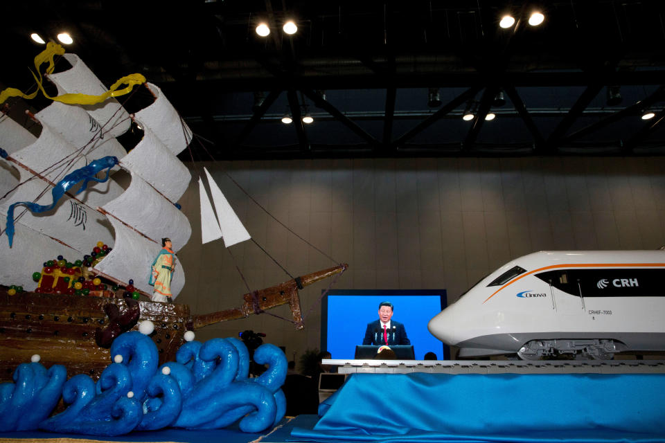FILE - Chinese President Xi Jinping's speech at the opening of the Belt and Road Forum is displayed on a big screen near decorations depicting Chinese Admiral Zheng He who commanded expeditionary voyages across Asia and East Africa in the 15th century and a modern high speed train on May 14, 2017, in Beijing. China's Belt and Road initiative has built power plants, roads, railroads and ports around the world and deepened China's relations with Africa, Asia, Latin America and the Mideast. It is a major part of Chinese President Xi Jinping's push for China to play a larger role in global affairs. (AP Photo/Ng Han Guan, File)