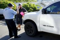 88-year-old Retired Senior Volunteer Patrol member Ed Robles (L) explains parking regulations to the roommate of a truck owner, while on patrol in San Diego, California, United States March 10, 2015. (REUTERS/Mike Blake)