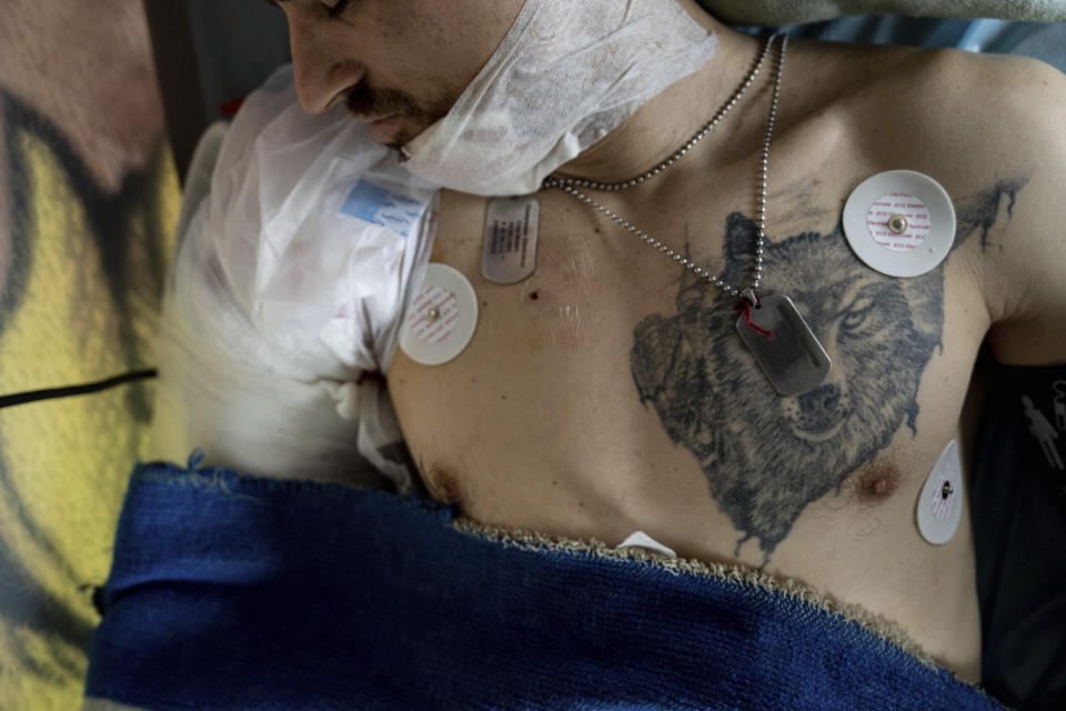 Oleksandr, an injured Ukrainian soldier, lies on a bed inside a special medical bus during an evacuation by volunteers from the Hospitallers paramedic organisation in Donetsk region, Ukraine, Wednesday, March 22, 2023. (AP Photo/Evgeniy Maloletka)