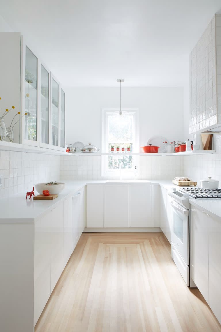 <p>When in doubt, stick to an all-white color scheme. This design trend never gets old (especially in the kitchen.) Add some pops of color with cookware and decor. Against an all-white backdrop, the red accent pieces in this Leanne Ford-designed kitchen appear to float in mid air.</p>