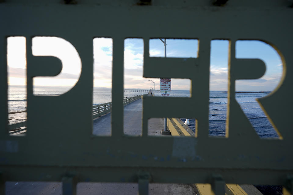 A gate to the Ocean Beach pier sits closed Tuesday, Jan. 30, 2024, in San Diego. Rising seas, frequent storms take toll on California's iconic piers, threatening beach landmarks. (AP Photo/Gregory Bull)