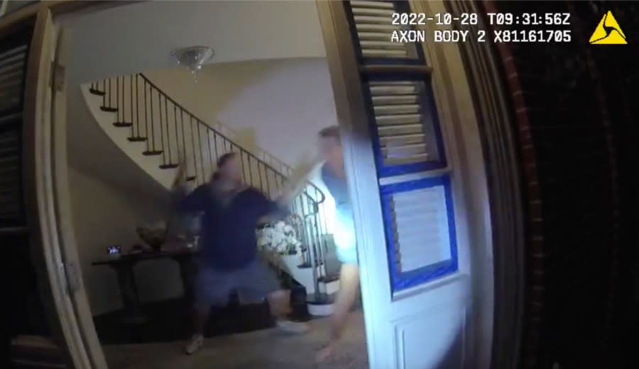 In this image taken from San Francisco Police Department body-camera video, Paul Pelosi, right, the husband of former U.S. House Speaker Nancy Pelosi, fights for control of a hammer with his assailant during a brutal attack in the couple’s San Francisco home on Oct. 28, 2022. The body-camera footage shows the suspect David DePape wrest the tool from the 82-year-old Pelosi and lunge toward him the hammer over his head. The blow to Pelosi occurs out of view and the officers — one of them cursing — rush into the house and jump on DePape. (San Francisco Police Department via AP)