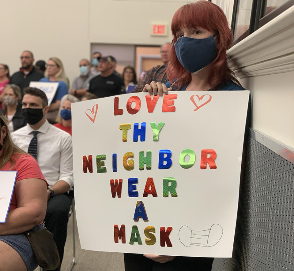 A Comal County ISD parent holds a sign in support of mask-wearing at the March 25 board meeting. (Bekah McNeel)