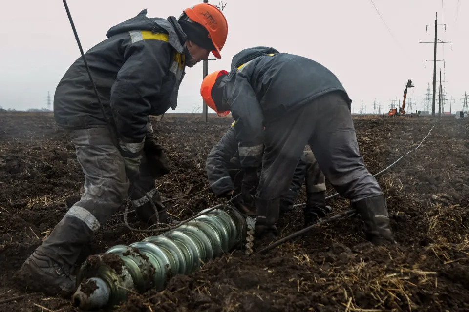 TOPSHOT - Workers repair high-voltage power lines cut by recent missile strikes near Odessa on December 7, 2022, amid the Russian invasion of Ukraine. - A new barrage of Russian strikes on December 5, left several Ukrainian cities without power, including the eastern city of Sumy and the southern city of Mykolaiv, according to officials. In Odessa, the water services operator said 