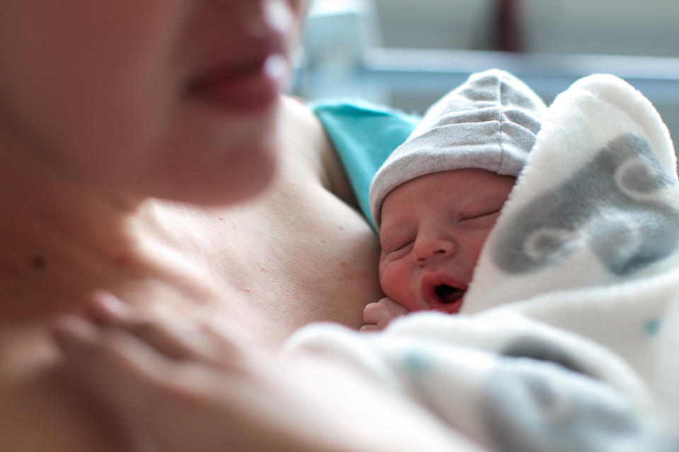 Newborn resting on a parent's chest, both appearing content and peaceful