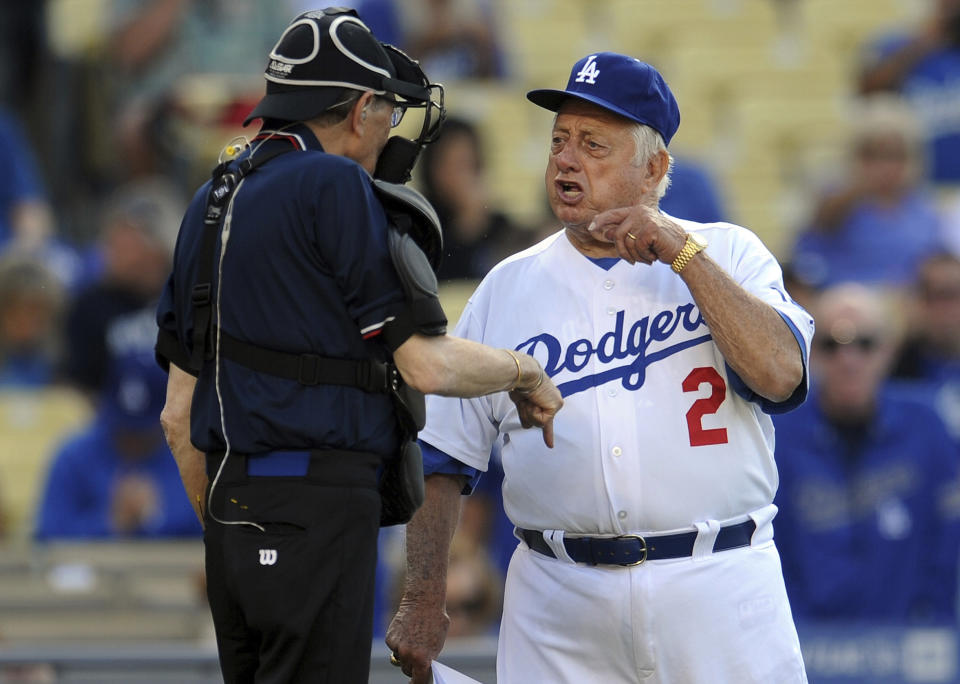 Former Los Angeles Dodgers manager Tommy Lasorda argues with home plate umpire Larry King, left, during the Old-Timers game prior to a baseball game between the Atlanta Braves and the Los Angeles Dodgers on Saturday, June 8, 2013, in Los Angeles. King, the suspenders-sporting everyman whose broadcast interviews with world leaders, movie stars and ordinary Joes helped define American conversation for a half-century, died Saturday, Jan. 23, 2021, at age 87. (Keith Birmingham/The Orange County Register/SCNG via AP)