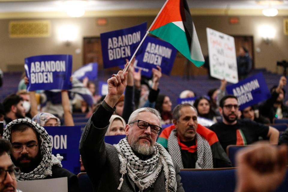 Attendees wave Palestinian flag and chant "Ceasefire Now" during a community rally to boycott President Biden's visit at Fordson High School in Dearborn on Wednesday, Jan. 31, 2024.