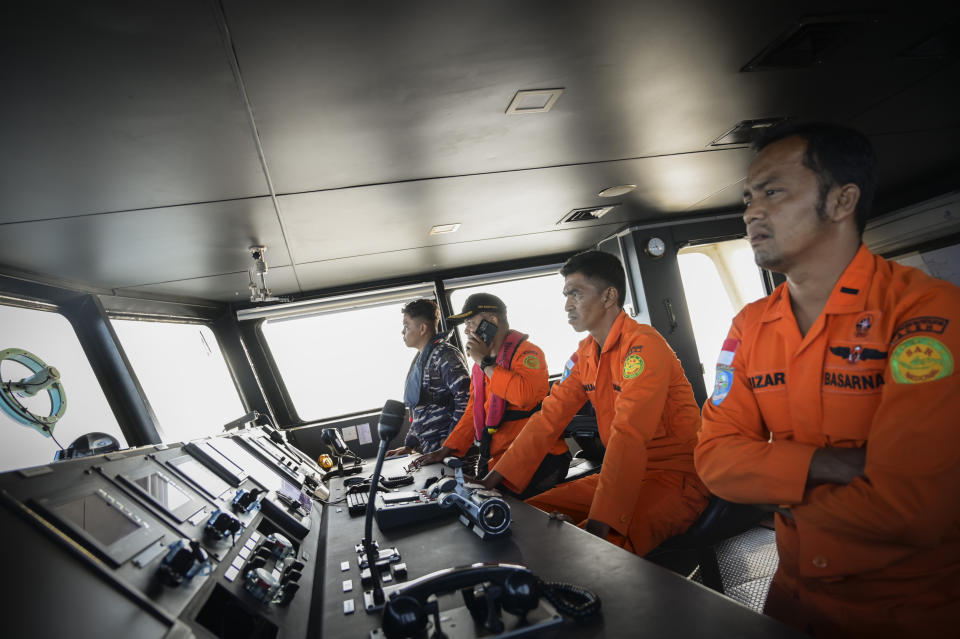 Members of Indonesia's National Search and Rescue Agency scan the horizon during the search for a capsized boat carrying Rohingya refugees off West Aceh, Indonesia, on Thursday, March 21, 2024. The wooden fishing boat carried about 140 Rohingya refugees, but only 75 people were rescued. In interviews with The Associated Press, eight of the survivors described abuses on board the fishing boat. (AP Photo/Reza Saifullah)