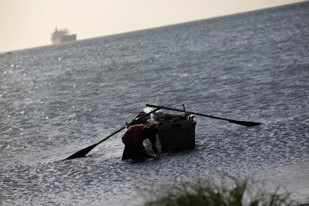 A man secures a boat at a pier in Port-au-Prince, Haiti, October 1, 2016. REUTERS/Andres Martinez Casares