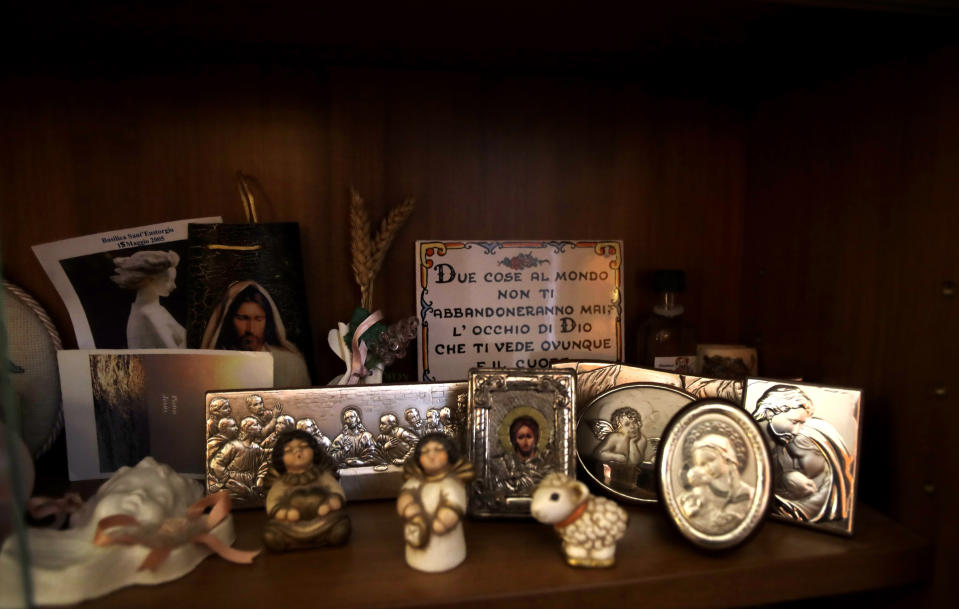 In this picture taken on Friday, Jan. 31, 2020 religious miniatures are displayed in a showcase at Yolanda Martinez Garcia's home, during an interview with the Associated Press, in Milan, Italy. Her son was sexually abused by one of the priests of the Legion of Christ, a disgraced religious order. (AP Photo/Luca Bruno)