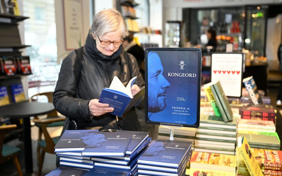 A woman flips through a copy of Konjol in a bookstore in Copenhagen.