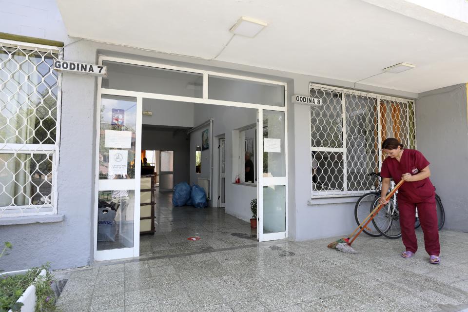 A cleaning woman mops the entrance of a student's campus which will be accommodate Afghans, in Tirana, Albania, Wednesday, Aug. 18, 2021. Albania are preparing for the arrival of Afghans who worked with Western peacekeeping forces in Afghanistan and are now threatened by the Taliban. (AP Photo/Franc Zhurda)