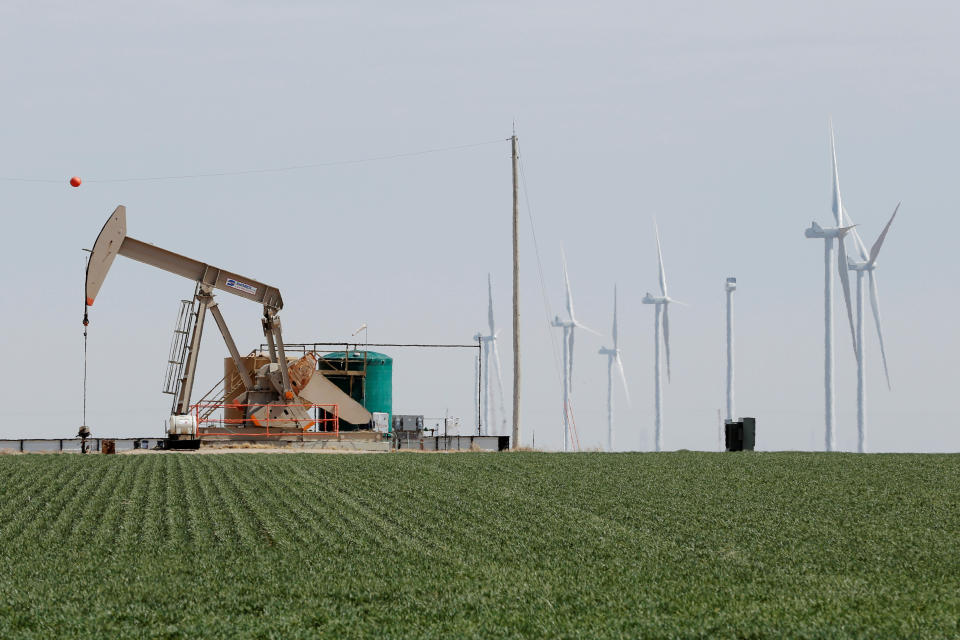 An oil derrick and wind turbines 