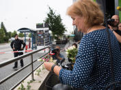 <p>A woman leaves flowers near a mall where a shooting took place, leaving nine people dead the day before, on July 23, 2016 in Munich, Germany. (Photo: Sebastian Widmann/AP)</p>