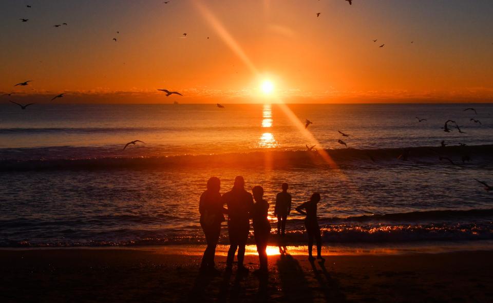 January 1, 2024 : The Bollinger family from Orlando come to the pier every New YearÕs Day to start their new year. The beach near the Westgate Cocoa Beach Pier has become a destination for people to watch the first sunrise of the new year. Young and old, people sit on the beach, stand near the water or walk along the shore taking photos, selfies, or just sit quietly and watch the new year begin.