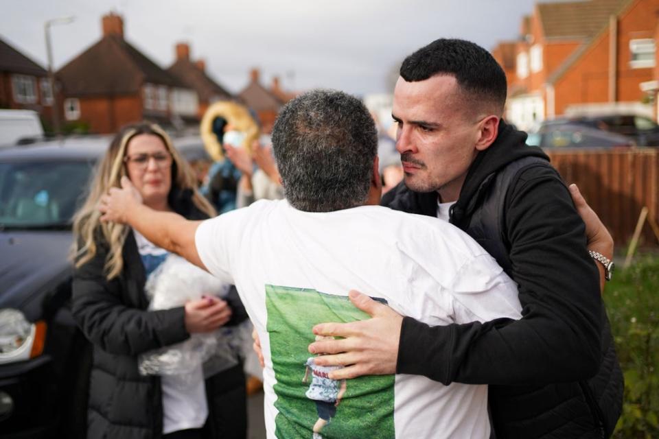 Family and friends embrace in the street (Jacob King/PA) (PA Wire)