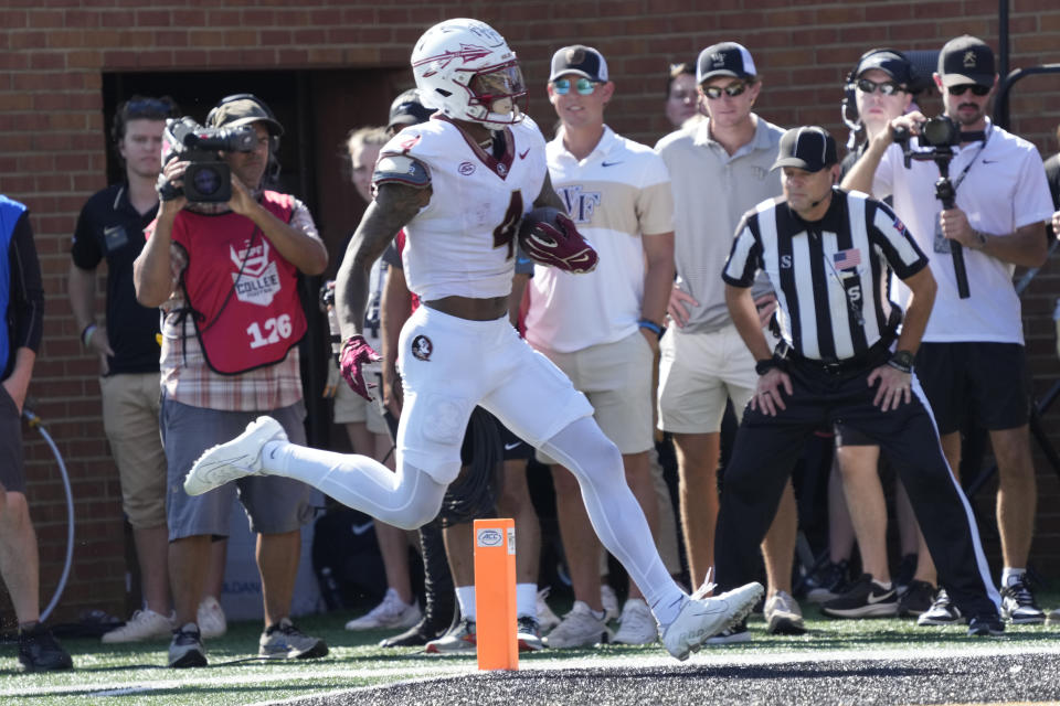 FILE-Florida State wide receiver Keon Coleman (4) runs for a touchdown after a catch against Wake Forest during the first half of an NCAA college football game in Winston-Salem, N.C., Saturday, Oct. 28, 2023. Could the fourth-ranked Seminoles, with a victory against defending national champion and No. 6 Georgia in the Orange Bowl be voted No. 1 in the final Associated Press college football poll? While voters say they would be open-minded to it, the current state of college football’s postseason all but renders the conversation moot. (AP Photo/Chuck Burton, File)