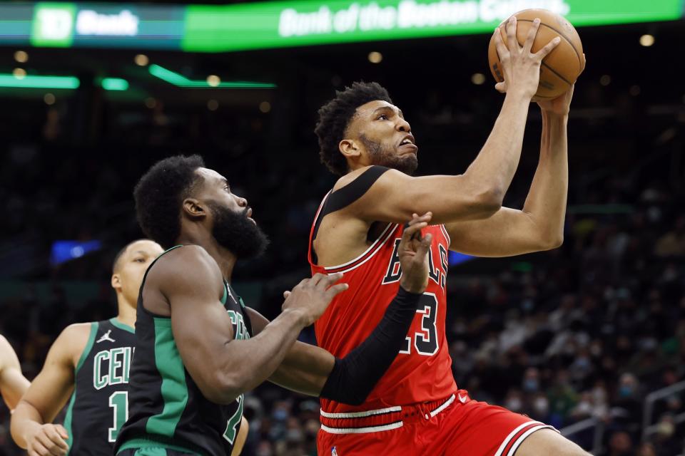 Chicago Bulls' Tony Bradley (13) drives for the net against Boston Celtics' Jaylen Brown (7) during the first half of an NBA basketball game, Saturday, Jan. 15, 2022, in Boston. (AP Photo/Michael Dwyer)