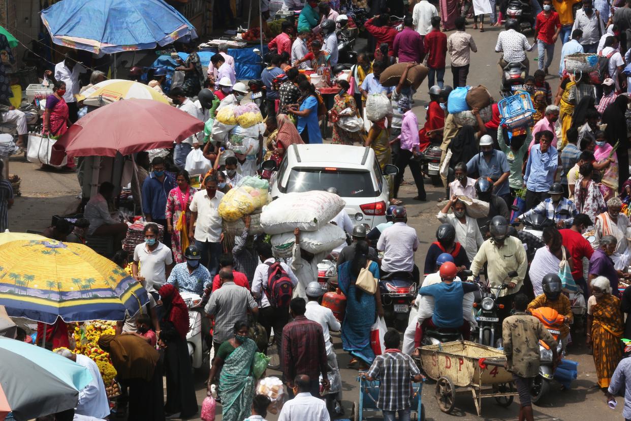 <p>People continue to gather in markets of crowded city area in Bengaluru, even as cases grow</p> (EPA)