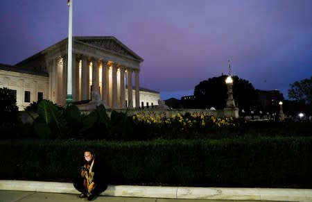 FILE PHOTO: Lone woman sits outside the U.S. Supreme Court in Washington