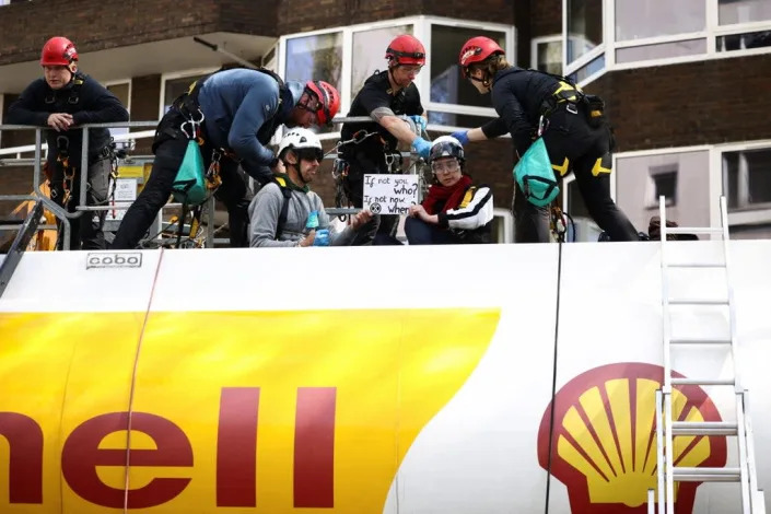 Police officers attempt to remove Etienne Stott, former Olympian, and an activist from Extinction Rebellion who occupied an oil tanker during a protest calling for an end to fossil fuels (REUTERS)