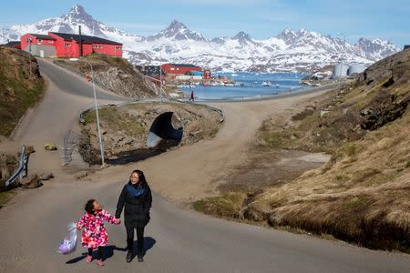 A woman and child hold hands as they walk on the street in the town of Tasiilaq, Greenland, June 15, 2018. REUTERS/Lucas Jackson