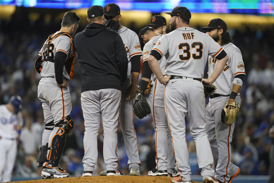 San Francisco Giants relief pitcher Jarlin Garcia, center, takes part in a mound conference during the third inning of Game 4 of a baseball National League Division Series against the Los Angeles Dodgers, Tuesday, Oct. 12, 2021, in Los Angeles. (AP Photo/Ashley Landis)