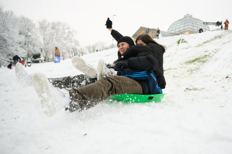 Two friends sledge down the hill at Alexandra Park on December 12, 2022 in London (Getty Images)