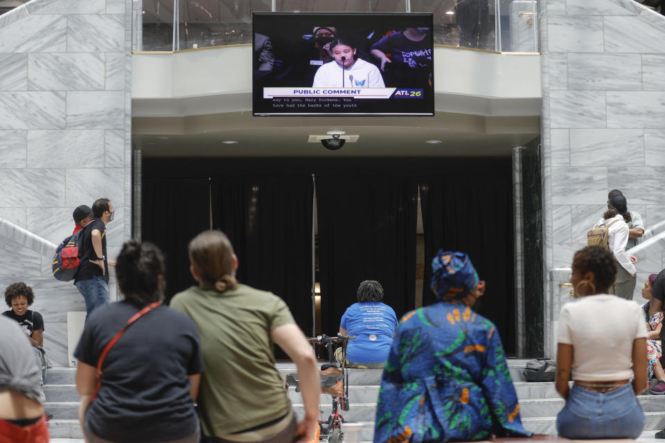 Protestors watch public comments on a screen in the atrium of Atlanta City Hall during a protest of the proposed police training center on Monday, June 5, 2023. (Natrice Miller/Atlanta Journal-Constitution via AP)