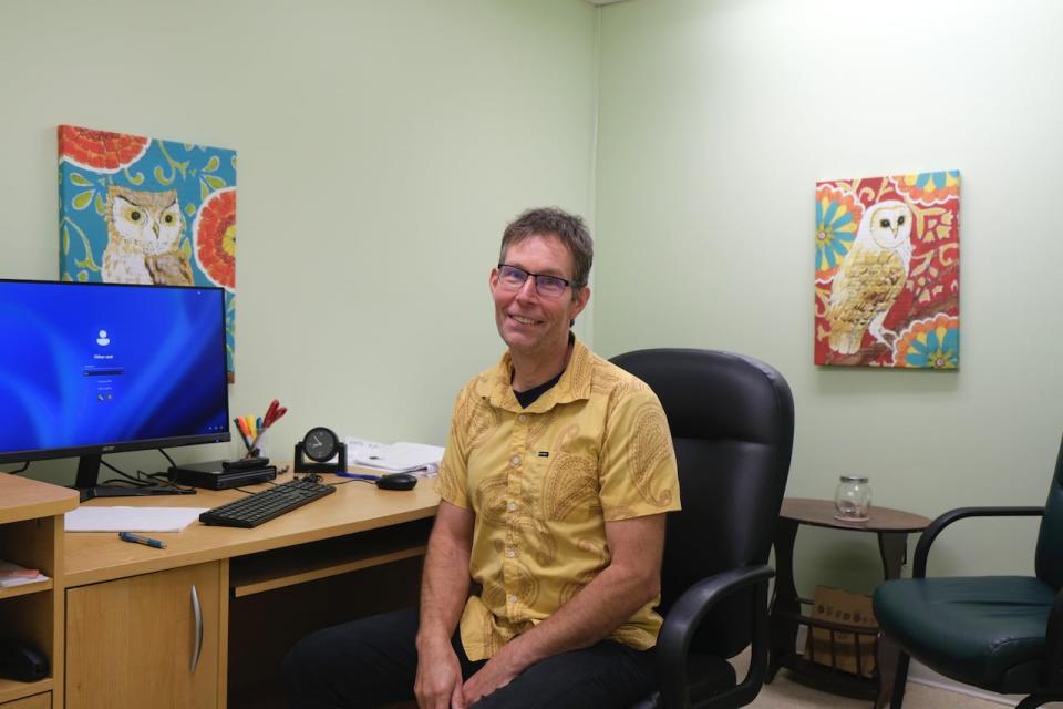 Nicholas Blenkinsop is sitting at a desk at the CLASSIC Law office in downtown Saskatoon on Sept. 13, 2024.