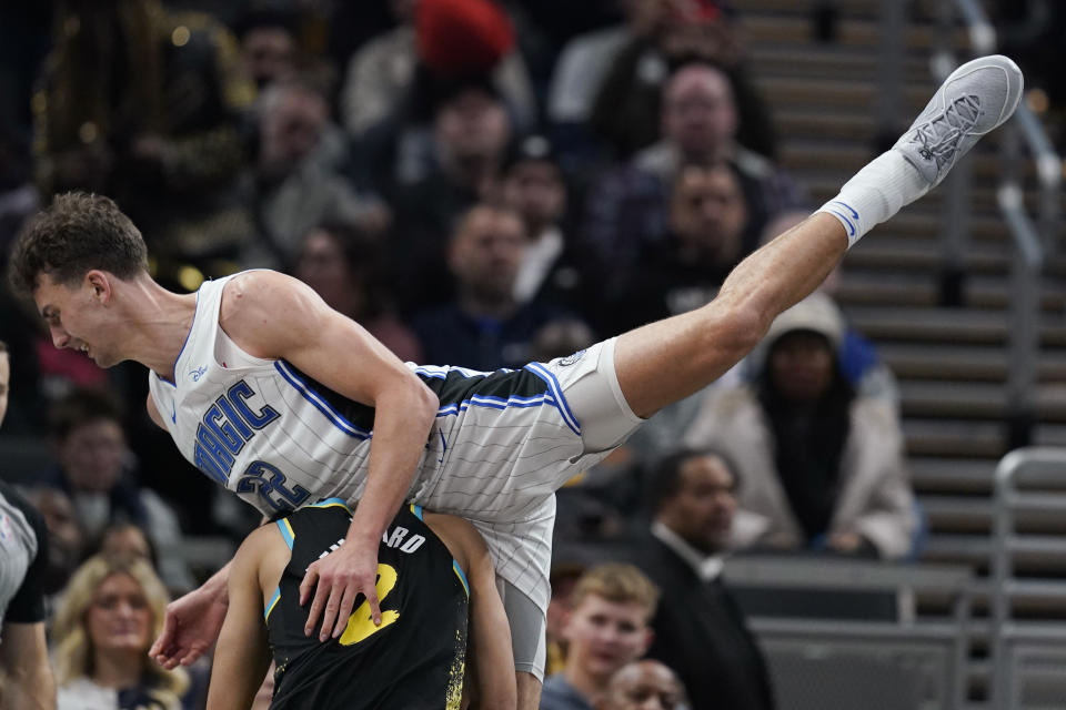 Indiana Pacers' Andrew Nembhard (2) is fouled by Orlando Magic's Franz Wagner (22) during the first half of an NBA basketball game Saturday, Dec. 23, 2023, in Indianapolis. (AP Photo/Darron Cummings)