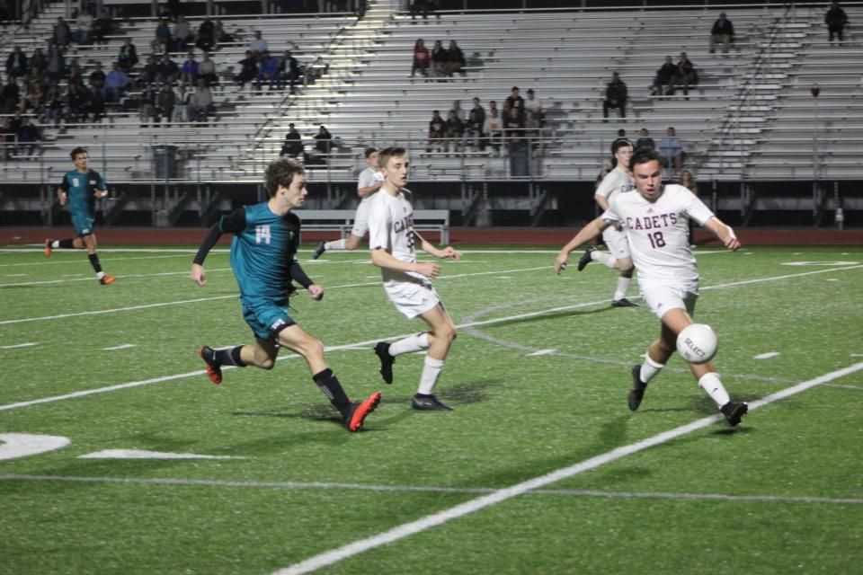 Benedictine's Andrew Kuyoth (No. 18) makes a play on the ball as Jack Schoeffler of Islands (No. 14) approaches in the Sharks 2-1 win on Feb. 9, 2023.