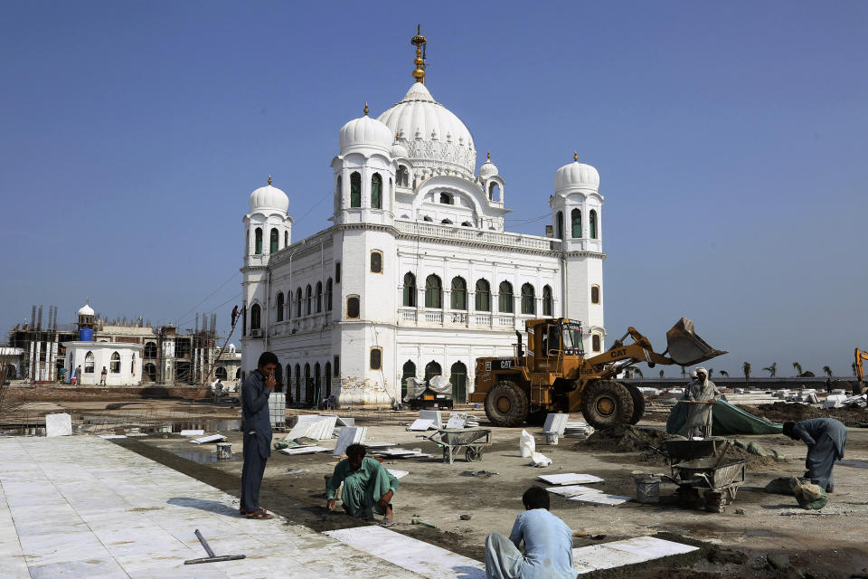 FILE - In this Sept. 16, 2019, file photo, Pakistani workers give finishing touches to the shrine of Sikh spiritual leader Guru Nanak Dev, in Kartarpur, Pakistan. Pakistan's prime minister has inaugurated a visa-free initiative that allows Sikh pilgrims from India to visit one of their holiest shrines. Imran Khan opened the border corridor on Saturday, Nov. 9, 2019 as thousands of Indian pilgrims waited to visit the Kartarpur shrine. (AP Photo/K.M. Chaudary, File)